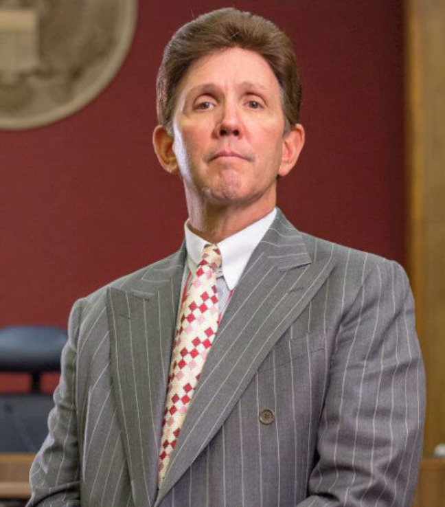 A man in a suit and tie standing up.