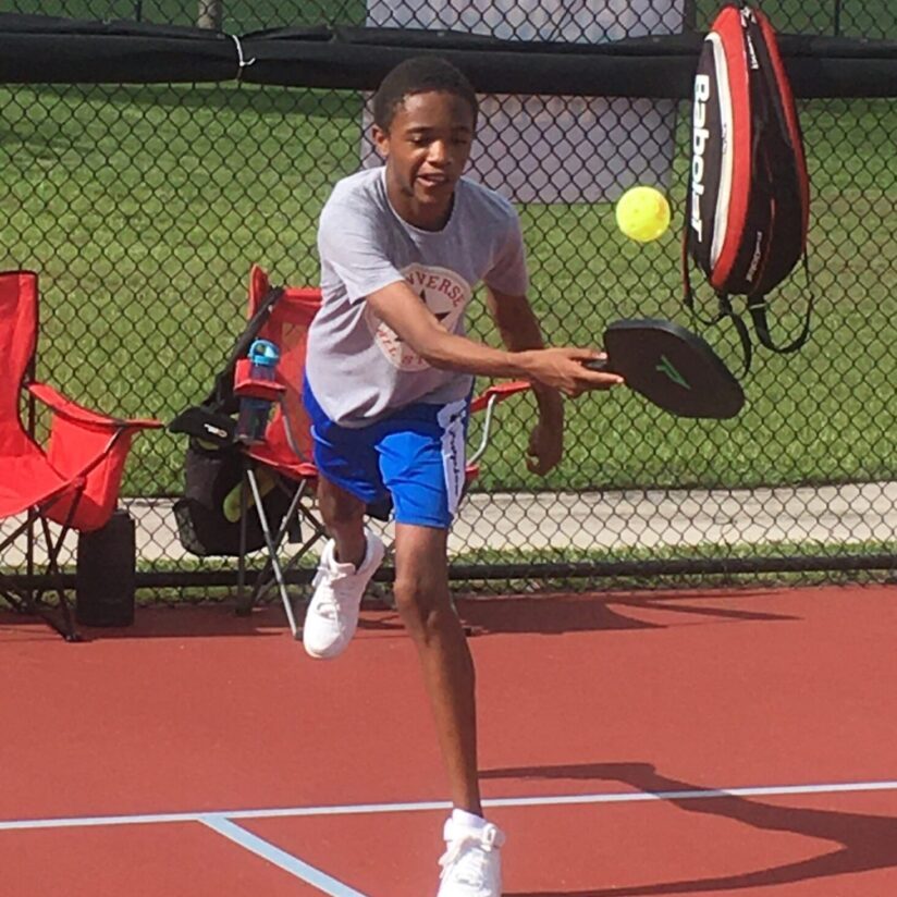 A man swinging at a tennis ball with his racket.